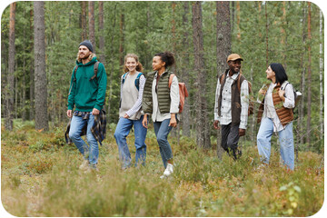 Lors d'une balade philo dans une forêt de Fribourg, un groupe de cinq personnes, hommes et femmes, marchent